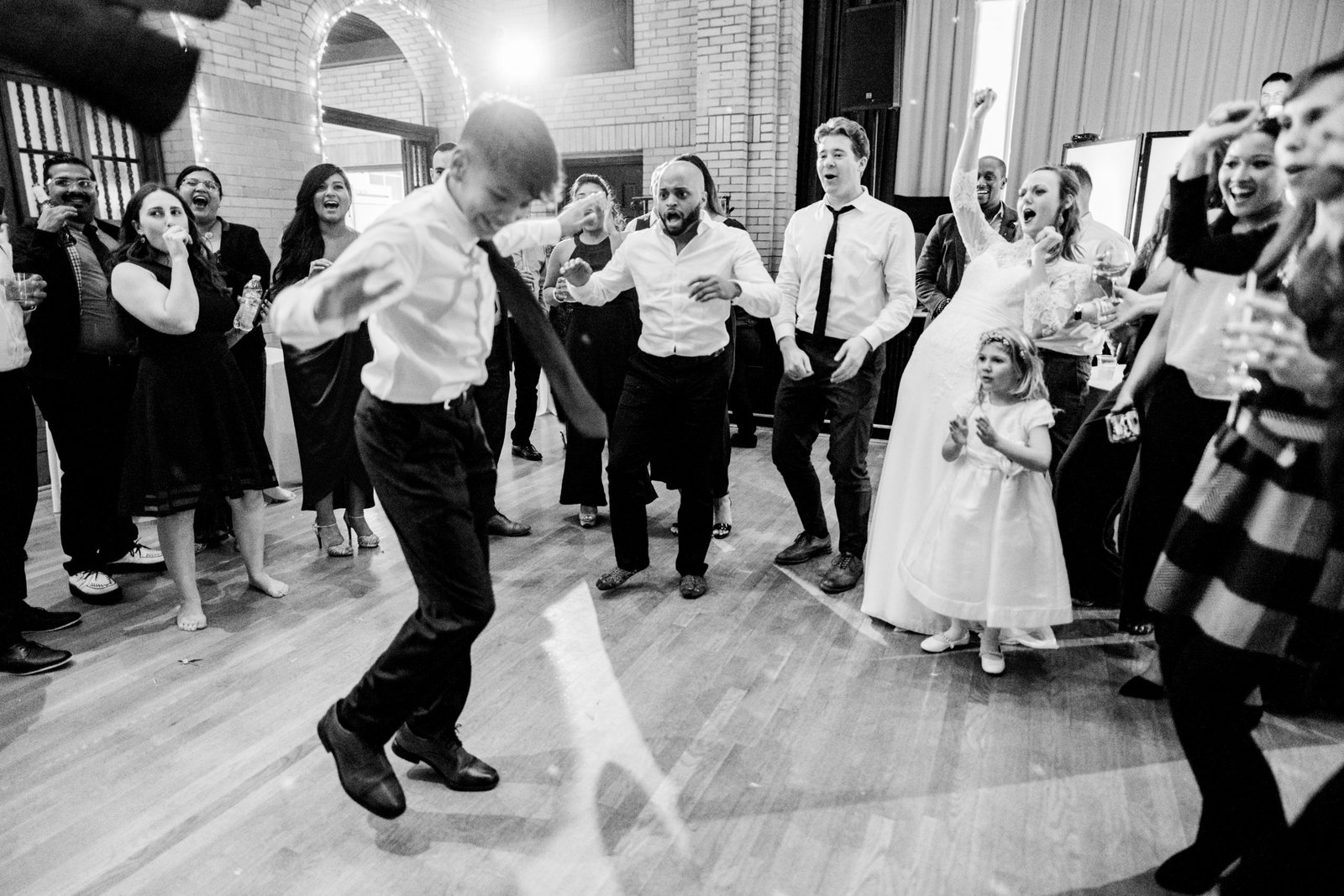 Bride and guests at a mixed American-Latin wedding in DC cheering on a dancer.