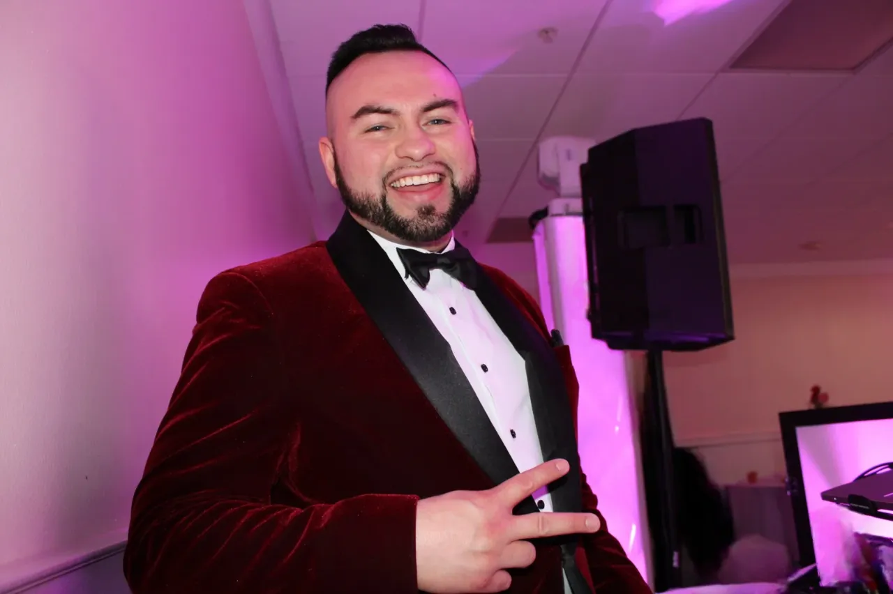 Elegance in Action - DJ Casanova Sets the Stage DJ Casanova in a velvet tuxedo and black bow tie, exuding elegance and professionalism at an event.